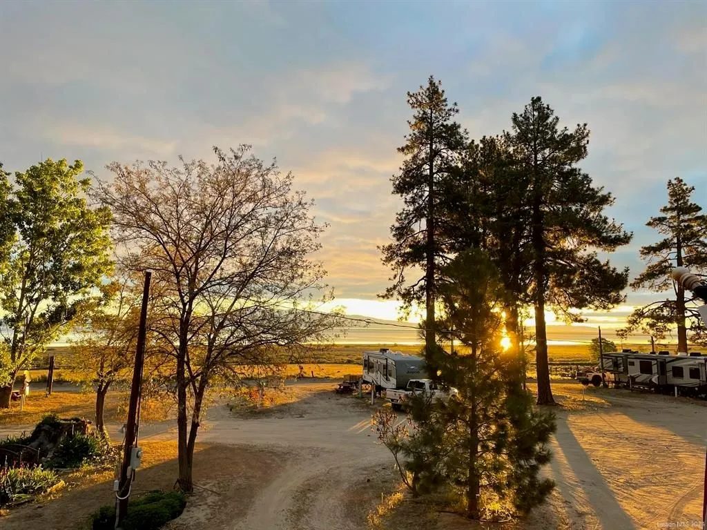 Sunset over trees, open land, and an RV camping area near Susanville
