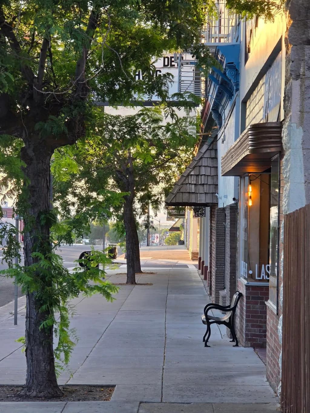 Downtown Susanville storefronts and sidewalk glowing at golden hour